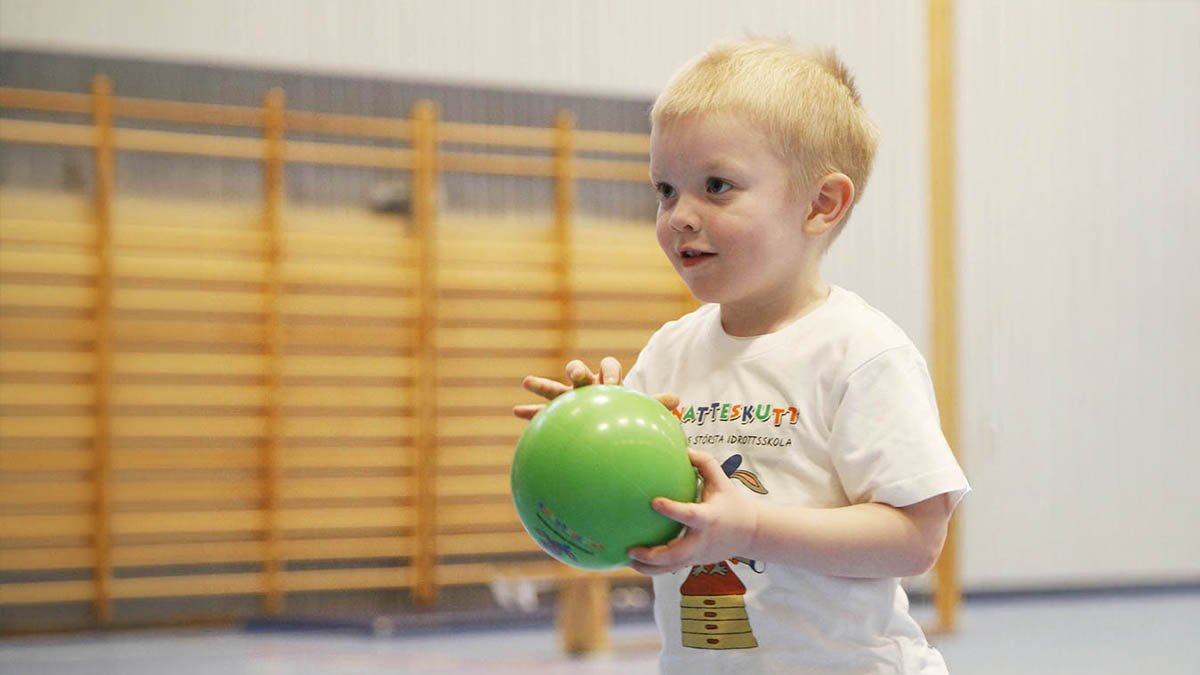 Litet barn håller Knatteskutt boll